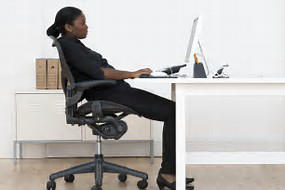 Woman working at desk improper posture slouching