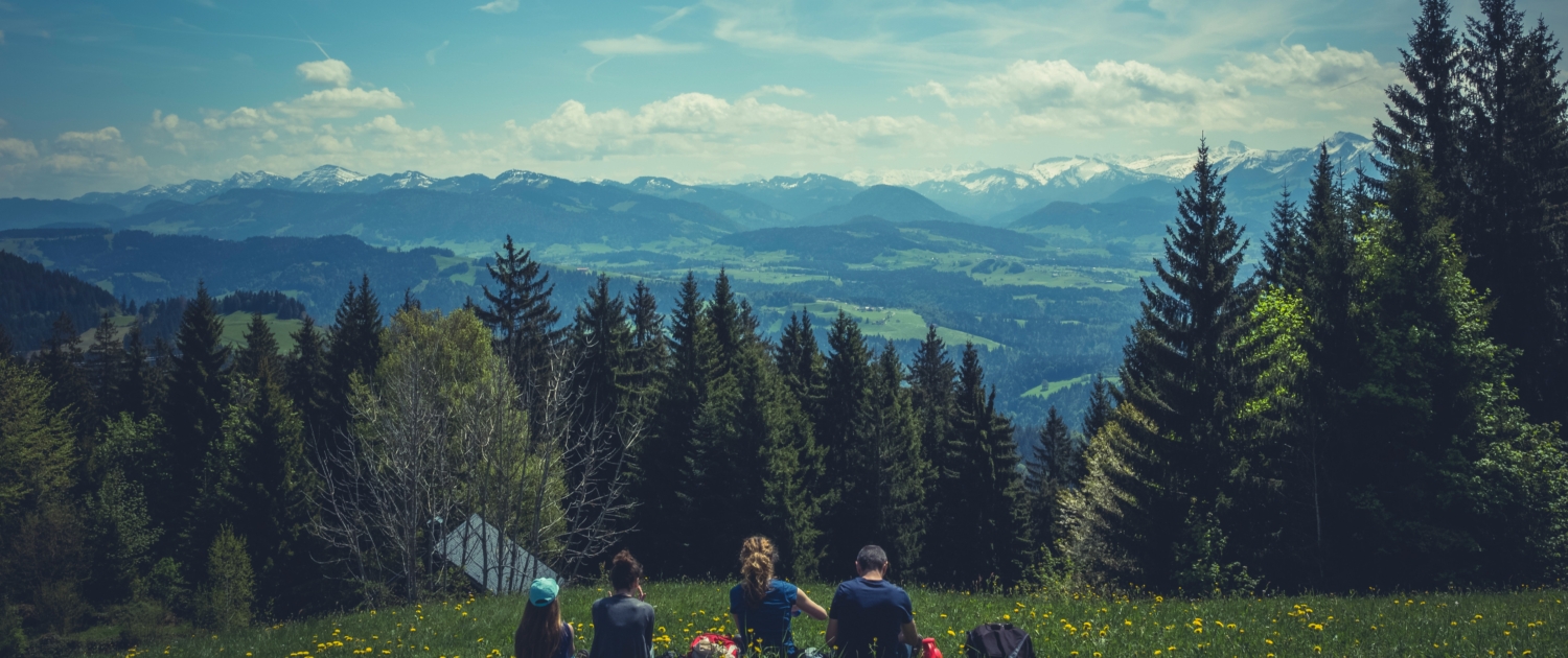 Friends in a meadow enjoying a mountain view photography